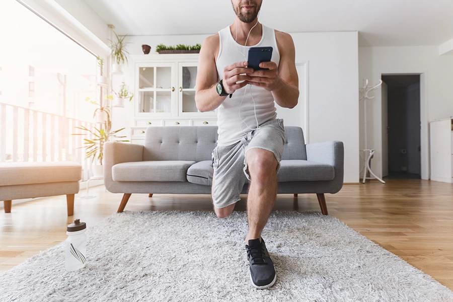 Men training at home with online fitness coaching app
